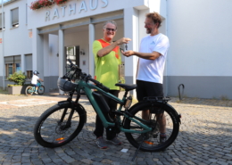 Stadtradeln-Star Leonhard Helm übergibt seinen Autoschlüssel an der Stadtradeln-Koordinatoren Christian Bandy